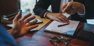 Handcuffs and documents on a desk during discussion.