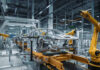 Car assembly line with robotic arms in a factory.