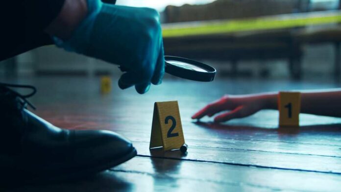 Detective,Collecting,Evidence,In,A,Crime,Scene.,Forensic,Specialists,Making A detective examining evidence at a crime scene with markers on the floor