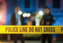Deadly Police Power Trip Police tape at a night scene with blurred officers in the background