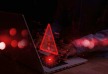 Mega-Church Hack Exposes Massive Flock Warning symbol over laptop with user.