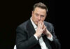 Musk’s Vow: Come For Them Elon Musk in suit thinking.