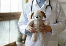 Doctor holding stuffed dog toy.