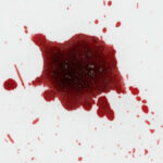 Red liquid splatter on a white background.