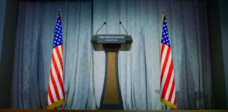 Podium between two American flags on a stage