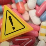 Warning sign among assorted pills and capsules