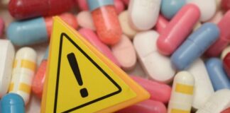 Warning sign among assorted pills and capsules
