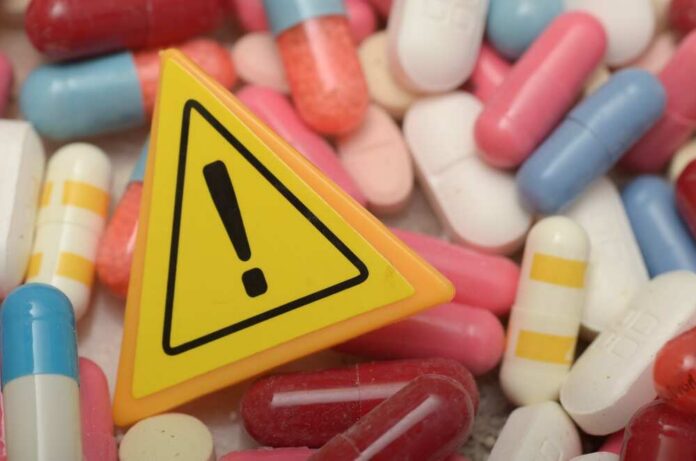 Warning sign among assorted pills and capsules