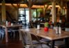 Interior of a cozy restaurant with wooden tables and decorative plants