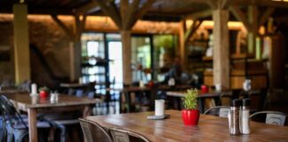 Interior of a cozy restaurant with wooden tables and decorative plants