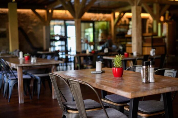 Interior of a cozy restaurant with wooden tables and decorative plants