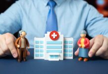 Nursing Home Gambit Drops Hands holding senior figurines beside a toy hospital building