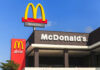 Million-Dollar Comeback: McDonald’s Plays Dirty-Smart McDonald's restaurant exterior with drive-thru signs against blue sky