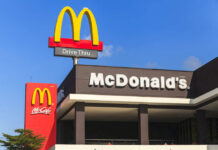 Million-Dollar Comeback: McDonald’s Plays Dirty-Smart McDonald's restaurant exterior with drive-thru signs against blue sky